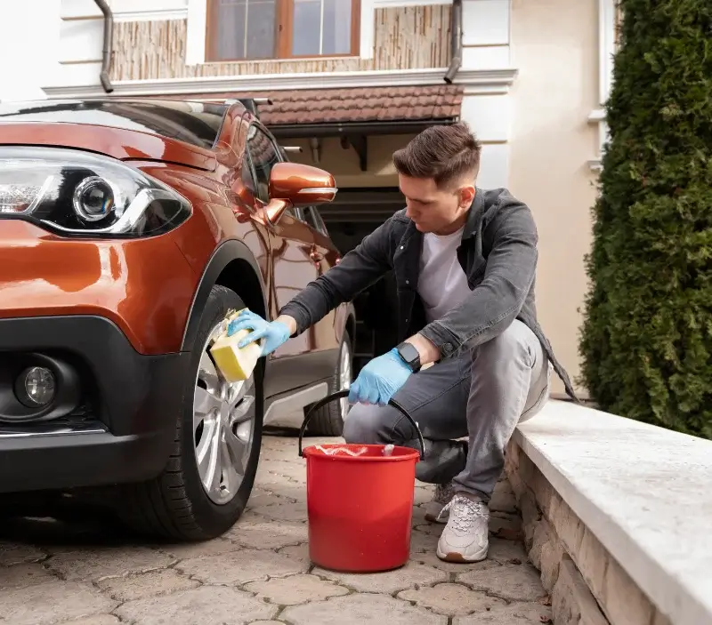 Lavage auto à domicile Charbonnières-les-Varennes : professionnel intervenant sur un véhicule